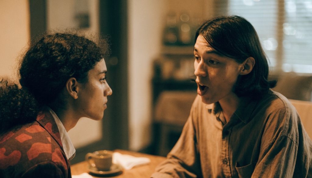 Casal sentado à mesa conversando, um ouvindo o outro com atenção