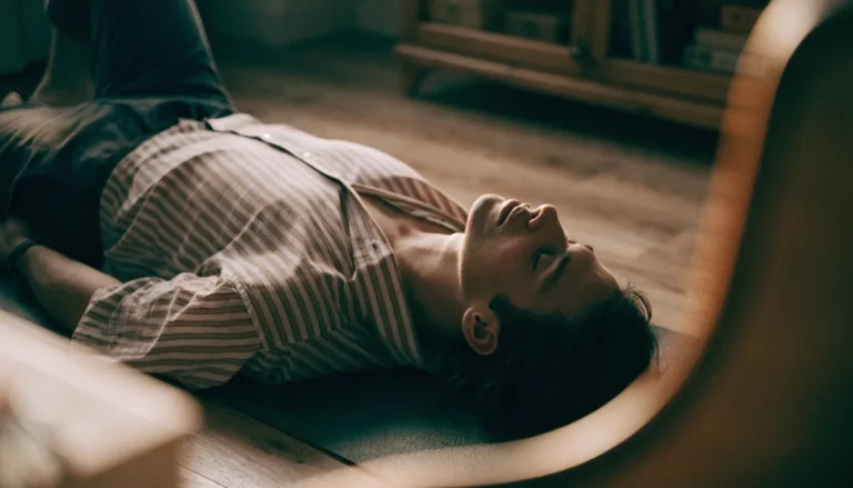 Homem deitado no tapete de yoga com os braços relaxados ao lado do corpo